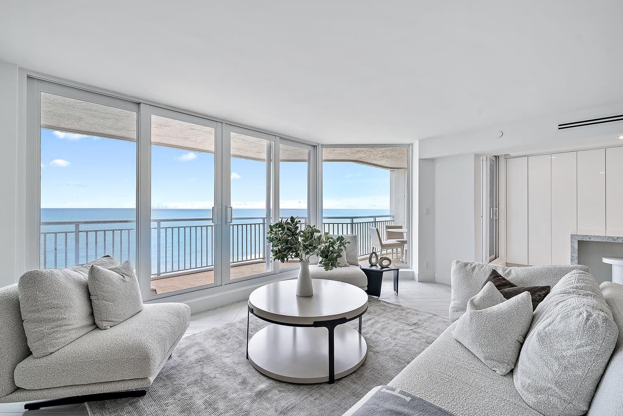 Palm Beach condo living room after the remodel, with white walls and an ocean view