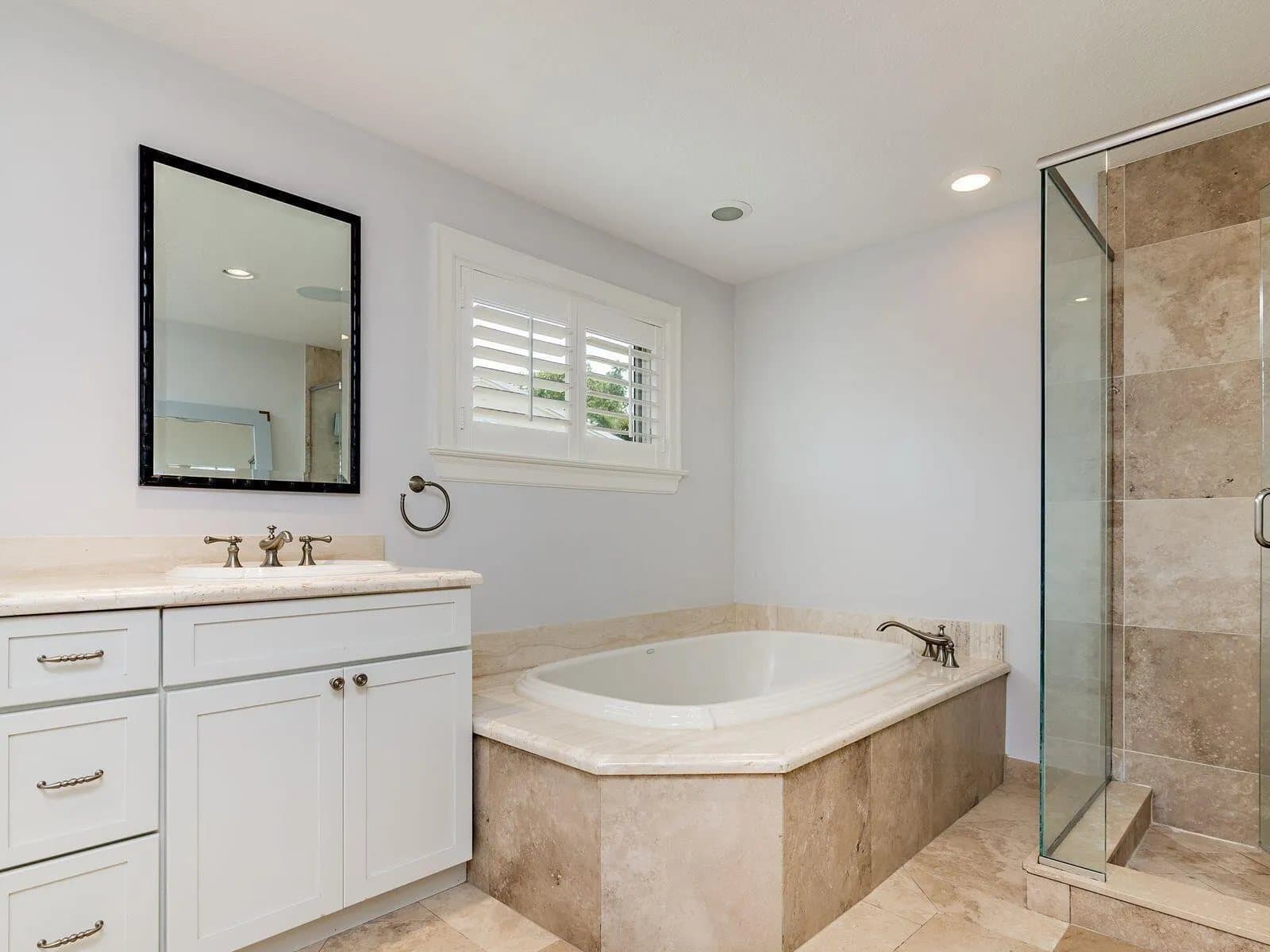 West Palm Beach primary bath before the remodel, with beige stone and a built-in tub
