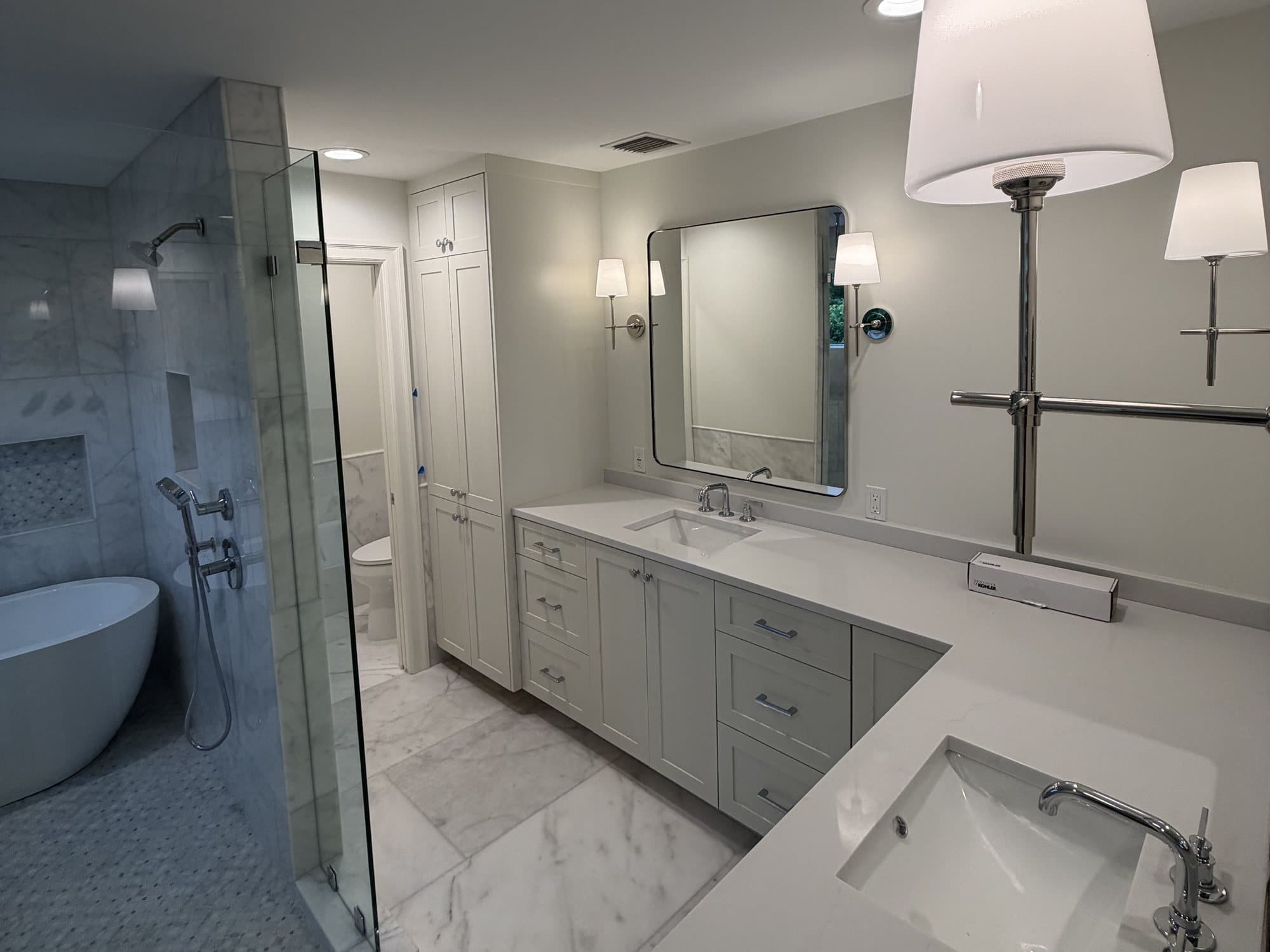 West Palm Beach primary bath after the remodel, with a glass shower, freestanding tub and double vanity